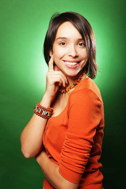 Beautiful young surprised woman over green background