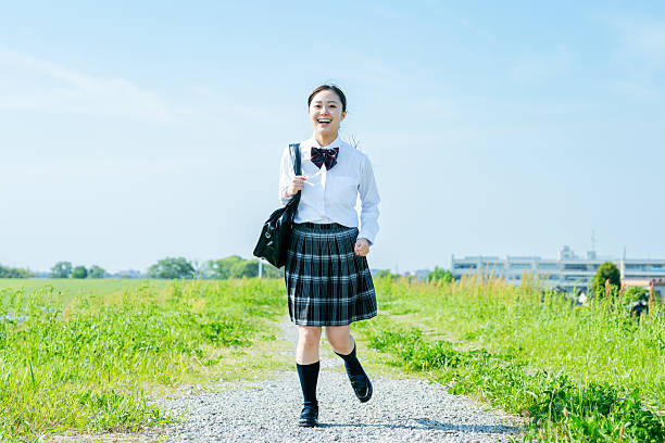 istock High school girl walking under the blue sky 2213981194