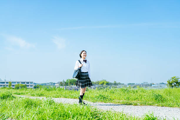 istock High school girl walking under the blue sky 2213981195