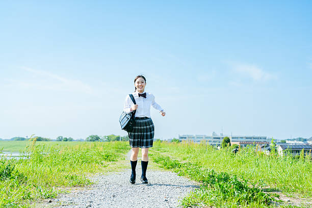 istock High school girl walking under the blue sky 2213981196