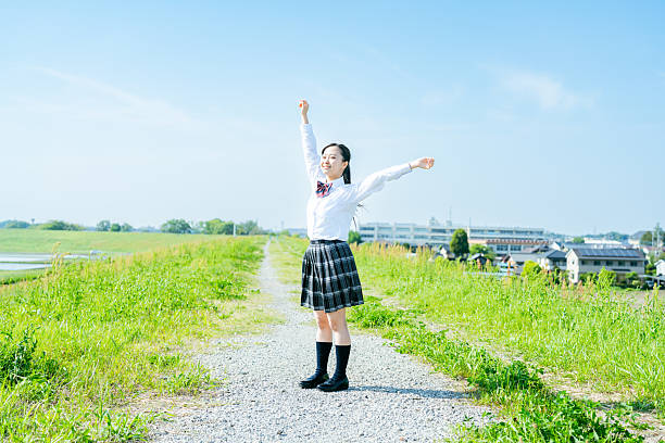 istock High school girl walking under the blue sky 2213981198