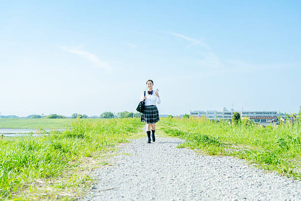 istock High school girl walking under the blue sky 2213981230