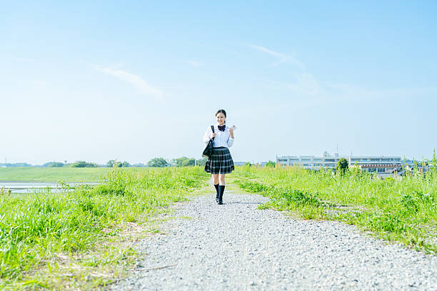 istock High school girl walking under the blue sky 2213981236