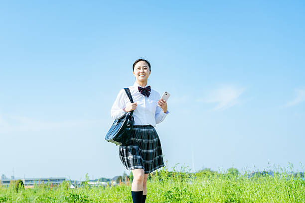istock High school girl walking under the blue sky 2213981237
