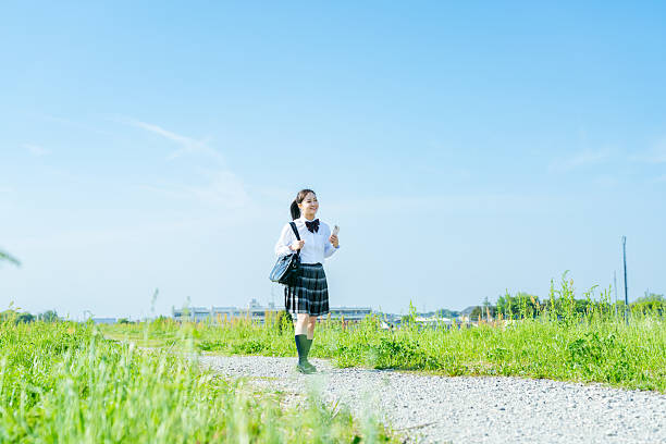 istock High school girl walking under the blue sky 2213981238