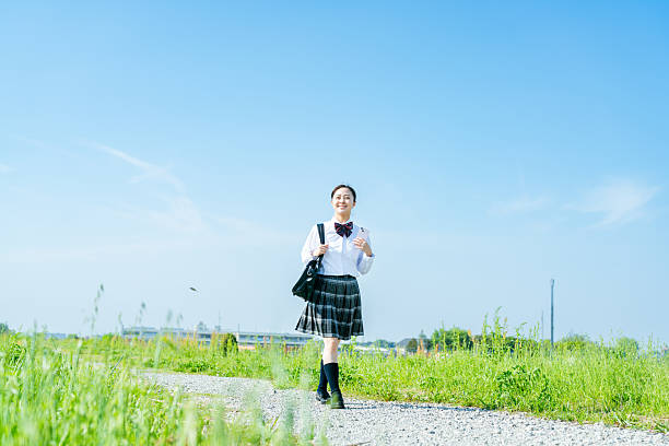 istock High school girl walking under the blue sky 2213981239