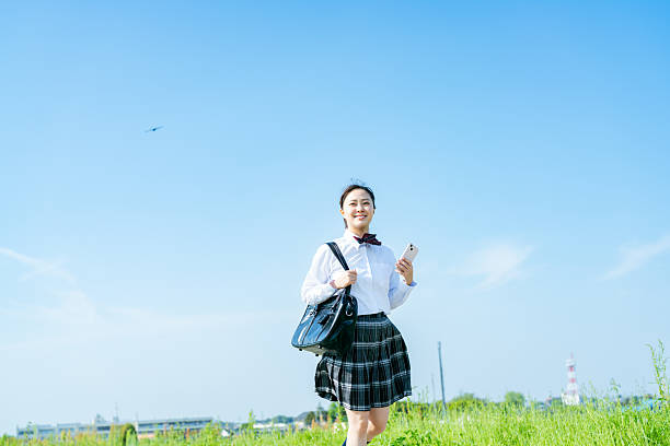 istock High school girl walking under the blue sky 2213981242