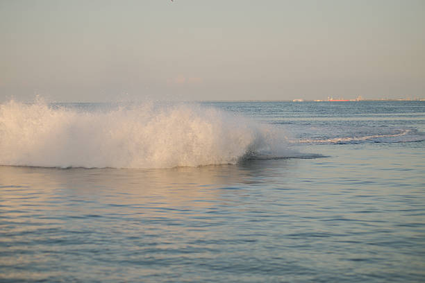 Near Coastal water at Sunset. A lone individual operates a blue jet ski in calm waters under warm evening light, near Skyway Bridge at Tampa Bay in Florida. Creating an adventurous and serene scene in nature.