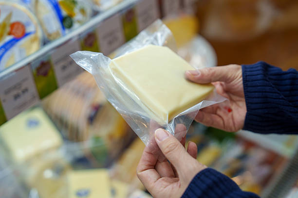 istock Hand Holding Packaged White Cheese in Supermarket 2213987518