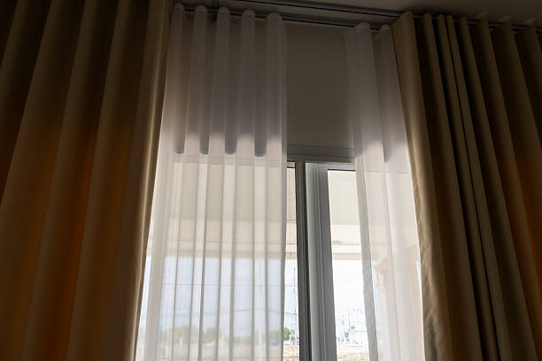 istock Light filtering through sheer curtains in modern living room indoor interior design bright atmosphere 2213989877