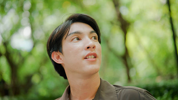 istock Young Asian man breathing fresh air while relaxing on a park bench. 2213991428