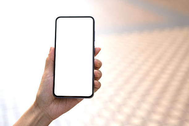 istock Hand Holding Smartphone with Blank Screen in Bright Corridor Walkway 2213991708