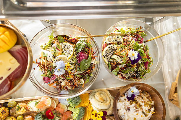 Variety of plates and bowls with green vegetables, chicken and fresh salads on a light background. Healthy food concept. Top view. Panorama.