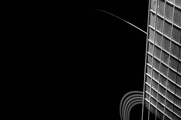 black acoustic guitar on a black background, silhouette. black and white, close-up, front side view