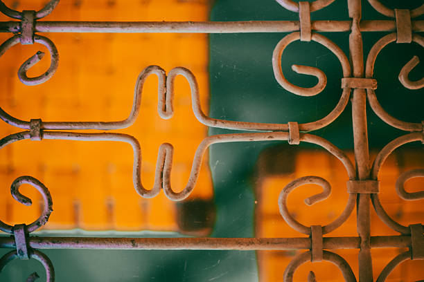 White carved cast iron railing close-up, gray painted wall background. Galicia, Spain.