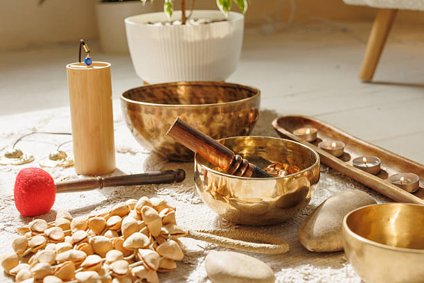 istock Tibetan sound bowls, incense, candles, and healing tools arranged for meditation session. 2214001076