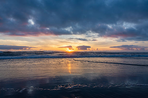 istock Stunning sunset over ocean waves with dramatic clouds reflecting golden hues in evening sky 2214002090