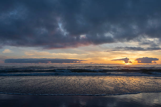 Beautiful sunset over the ocean with reflections on the sand during a calm summer evening