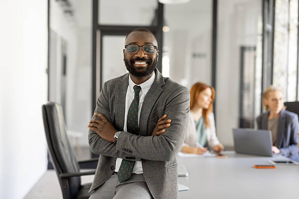 istock Confident smiling businessman with colleagues in office 2214002575