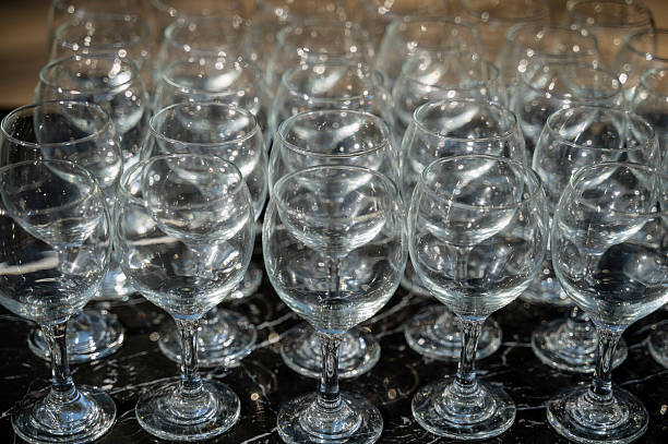 istock Many empty clean wine glasses on dark background in daylight 2214003423