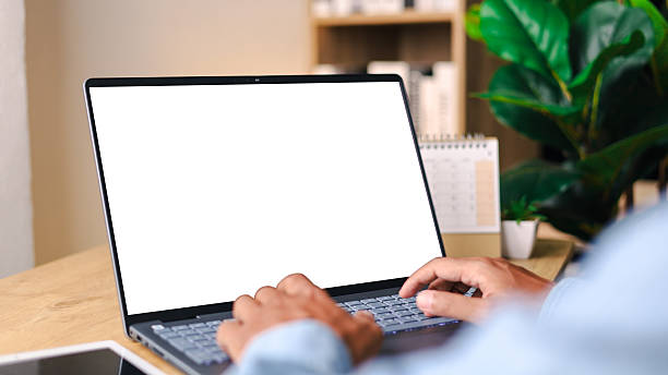 istock Mockup laptop computer. Businessman using laptop with empty screen on wooden table. 2214006358