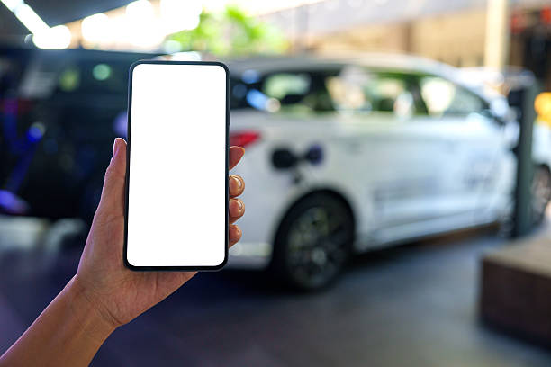 istock Hand Holding Smartphone with Blank Screen Near Electric Vehicle 2214006543
