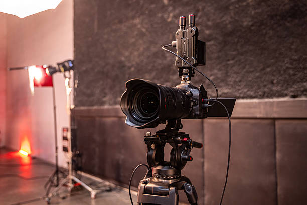 istock Filming equipment. Professional video camera. Condenser microphone. Camera for online broadcasting. Speaker microphone in spotlight. Camera for filming concert. Microphone for event host 2214007568