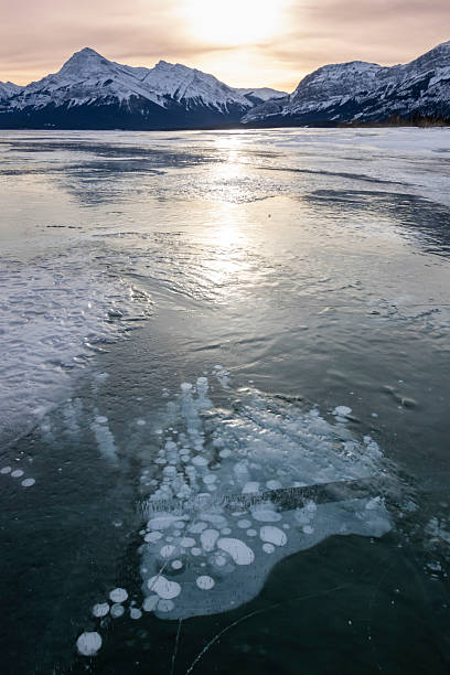 istock Bubbles trapped in the freezing Abraham Lake create stunning patterns against snowy mountains at sunset 2214007833