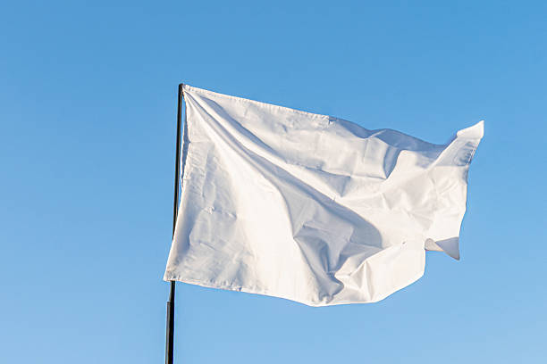 istock A rectangular, white flag with fringed edge fluttering against a clear blue sky The flag is suspended from an off-frame pole a 2214009252