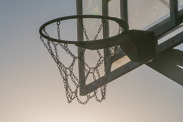 istock A sharp focus basketball hoop against a softly blurred sky backdrop, suggesting sunrise or sunset No markings on the hoop Candid style, no posed elements Perspective from below looking up 2214009302