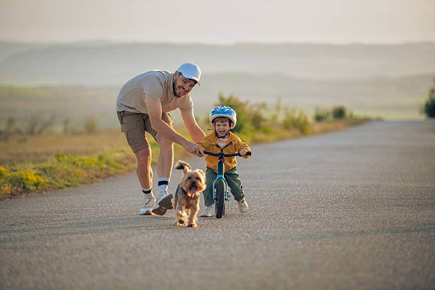 istock Father teaching son to ride a bicycle. 2214009946