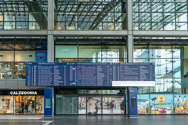 Berlin, Germany - April 16, 2025: Modern architecture of Berlin Hauptbahnhof with glass facade. Busy transportation hub with taxis and pedestrians at daytime.