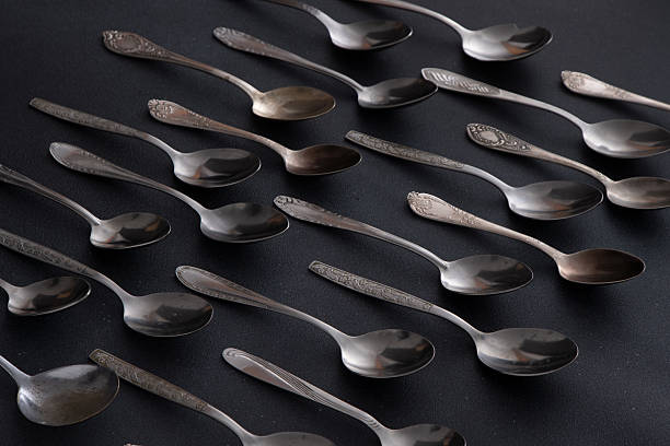 istock Set of different spoons. Silver cutlery on a black background. Spoon on the table 2214014982