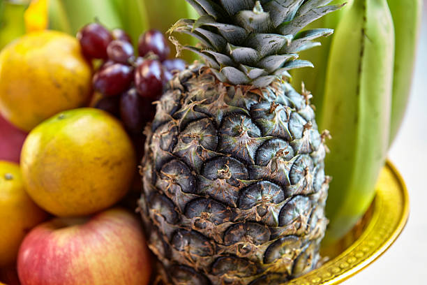 Ripe pineapple with orange and apple serving in plate