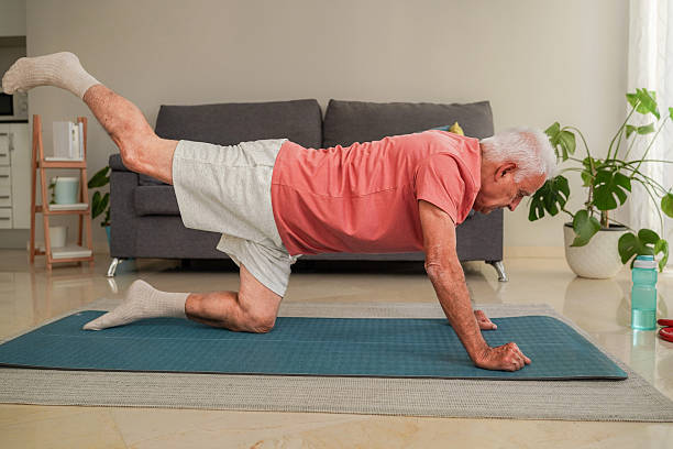 istock Senior man doing donkey kicks exercise on yoga mat at home 2214018512
