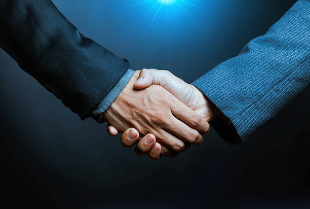 Businessmen shake hands to work as a team. Two businessmen shake hands with partners to celebrate the concept of cooperation and business deal. Negotiation success. Shake hands.