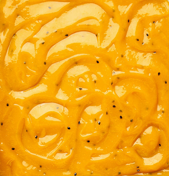 istock Passionfruit and mango jam texture with swirls and pulp in a close up on the surface. Bakery dessert concept. Full frame delicious background. 2214020067