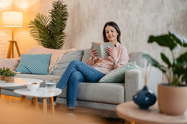 istock Young Woman Reading A Book At Home 2214023986