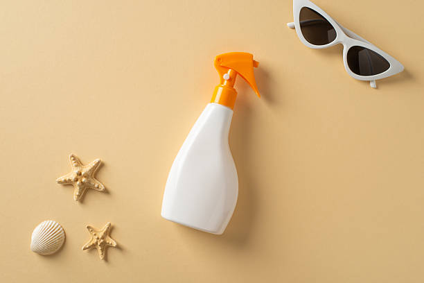 istock Flat lay composition of sunscreen bottle, sunglasses, and summer-themed elements against a yellow background 2214025563