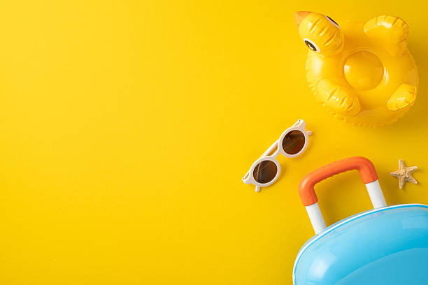 istock Flat lay image of travel essentials including sunglasses, inflatable ring, suitcase, and starfish, emphasizing summer vacation and beach relaxation. 2214025699