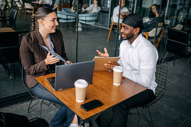 istock Insurance agent meeting with client at cafe trying to close deal talking while using laptop 2214026639