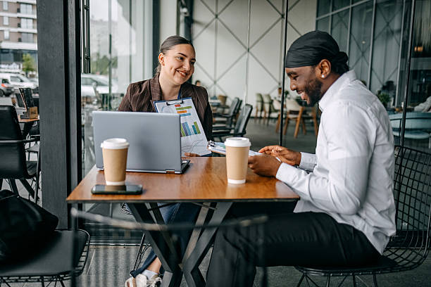 istock Insurance agent meeting with client at cafe trying to close deal talking while using laptop 2214026651