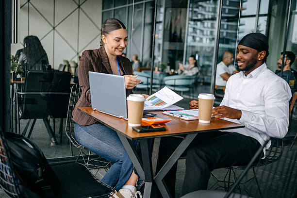istock Insurance agent meeting with client at cafe trying to close deal talking while using laptop and asking for client signature 2214026691