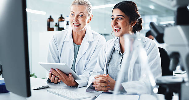 istock Research, science and women with tablet, computer and smile with cure development. People, scientist and teamwork with biotech, email for funding or test results for medical experiment or cooperation 2214027430
