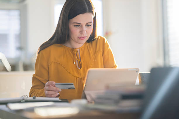 istock Focused Young Woman Using Tablet for Online Shopping in Bright Indoor Setting 2214027885