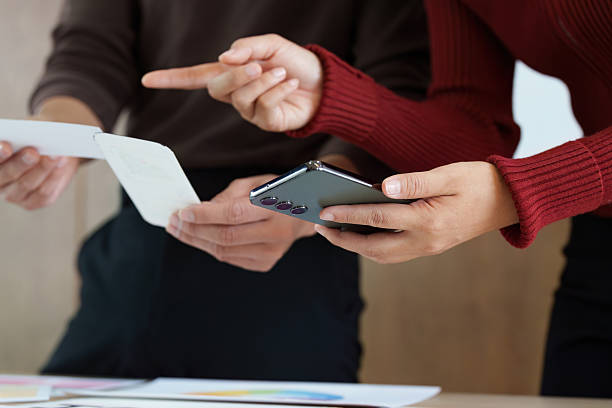 istock Business Collaboration and Communication. Two colleagues engaged in a discussion, sharing ideas and feedback over a smartphone. 2214030586