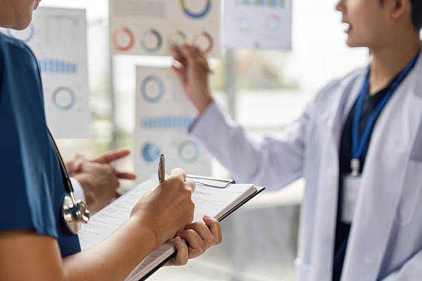 Doctor team discussing patient data and statistics in medical setting