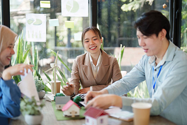 istock Collaboration and Sustainability. A team discusses eco-friendly architecture in a meeting surrounded by greenery. 2214032132