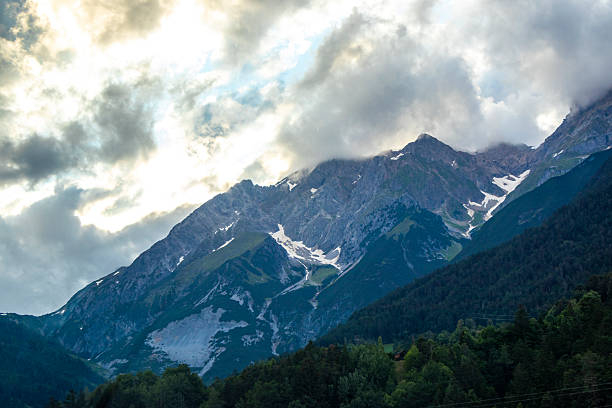 istock Mountain landscape mountains green fields forest clouds in Tyrol Austria. 2214033570