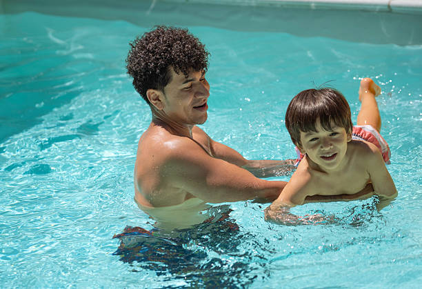 istock Young father teaching his son to swim in a pool 2214036108